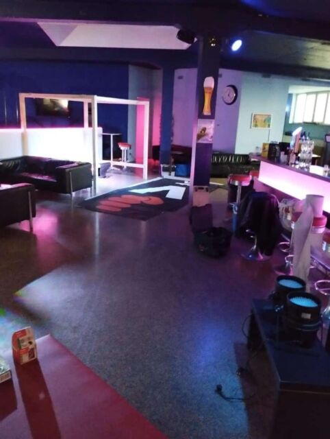 Eine bar im absorptiven licht, mit loungem&ouml;beln und einer tanzfl&auml;che im hintergrund.