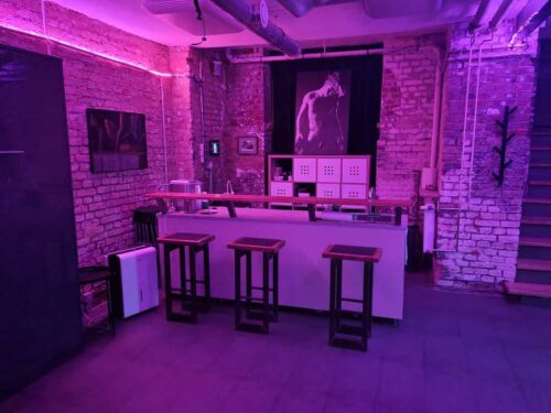 Fistwerk Bar mit Lounge, braune St&uuml;hle, Neonbeleuchtung und Wanddekoration, stilvoller Raum.