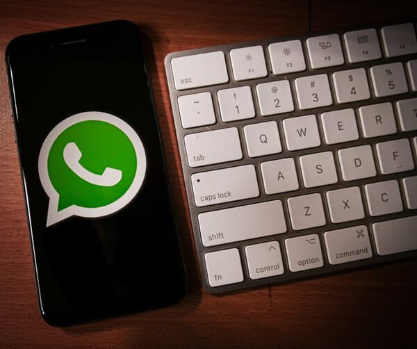 Fahrbares Smartphone mit WhatsApp Logo neben Keyboard.