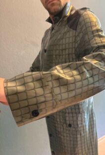 Eine Person trägt einen PVC-Gummi-Outfit mit Netzdesign. Perfekt für Fetisch, BDSM und Fisting.