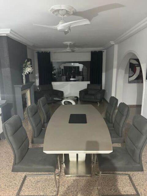 Moderner Konferenzraum mit großem Tisch und schwarzen Ledersesseln, ideal für Meetings und Besprechungen in einem eleganten, gut ausgestatteten Büro.
