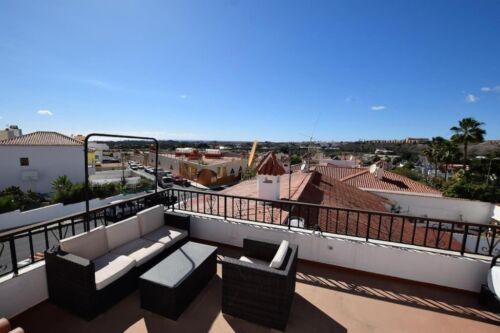 Gemütliche Dachterrasse mit Sitzbereich und Blick auf die Stadt bei sonnigem Himmel. Perfekt für entspannte Stunden im Freien und um die Aussicht zu genießen.