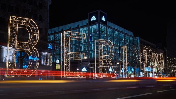 Beeindruckendes Lichtkunst-Display in Berlin bei Fistwerk, mit leuchtenden Buchstaben und moderner Architektur bei Nacht, perfekt für Events, Partys und kreative Veranstaltungen.
