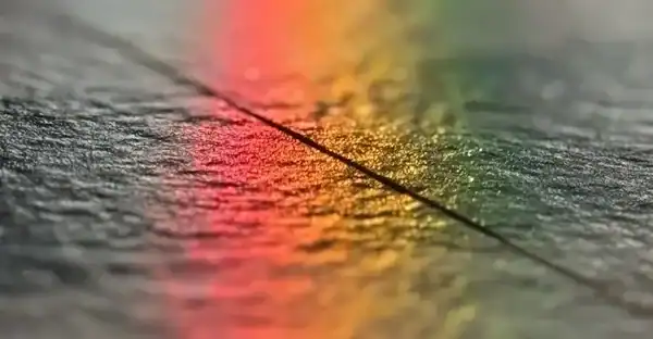 Nahaufnahme eines Fistwerks, das auf einer glatten Oberfläche liegt, mit bunten Reflexionen im Hintergrund.